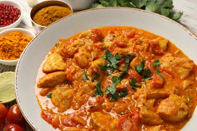 Photo of Delicious chicken curry and ingredients on table, closeup