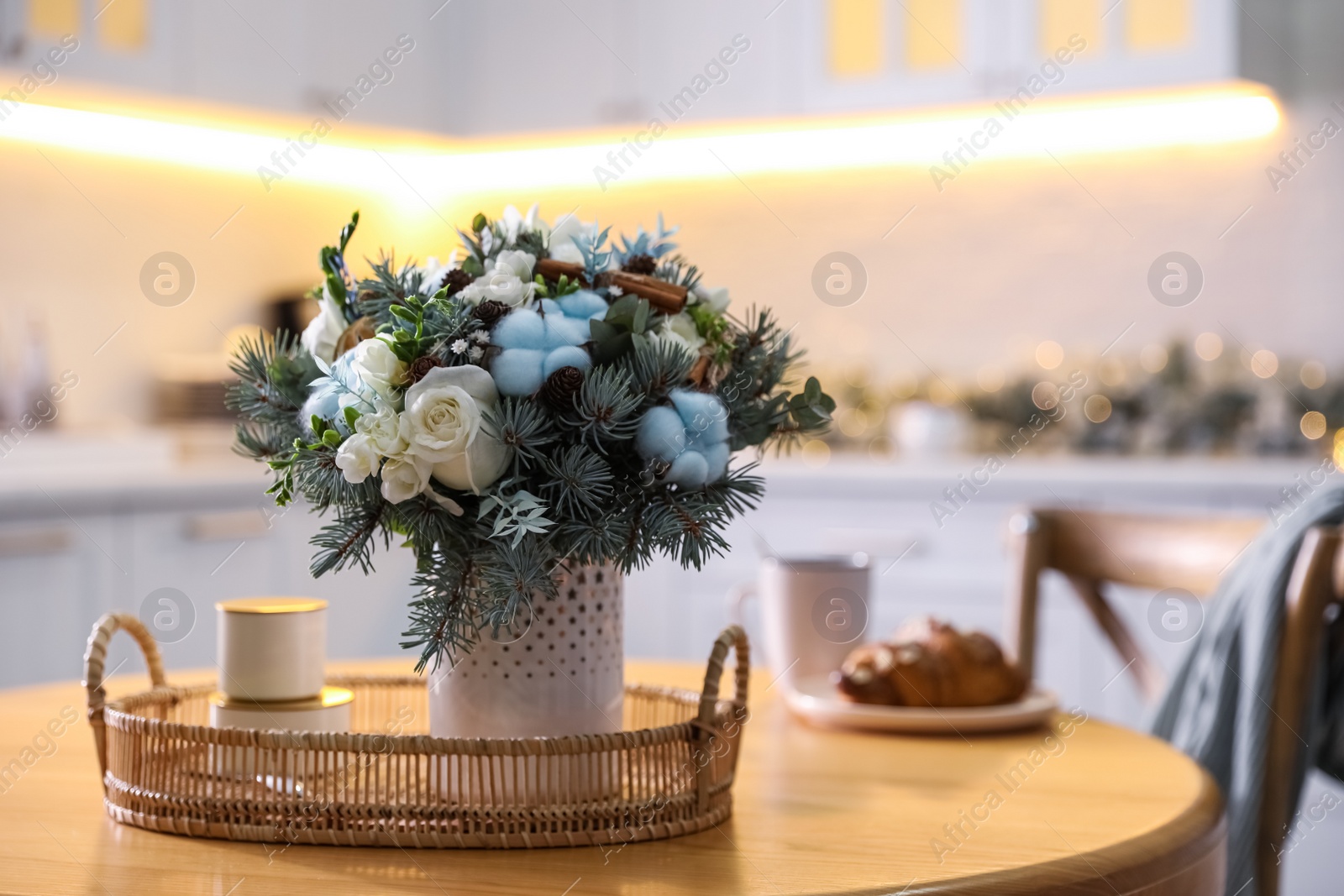 Photo of Beautiful winter bouquet on wooden table in kitchen. Space for text