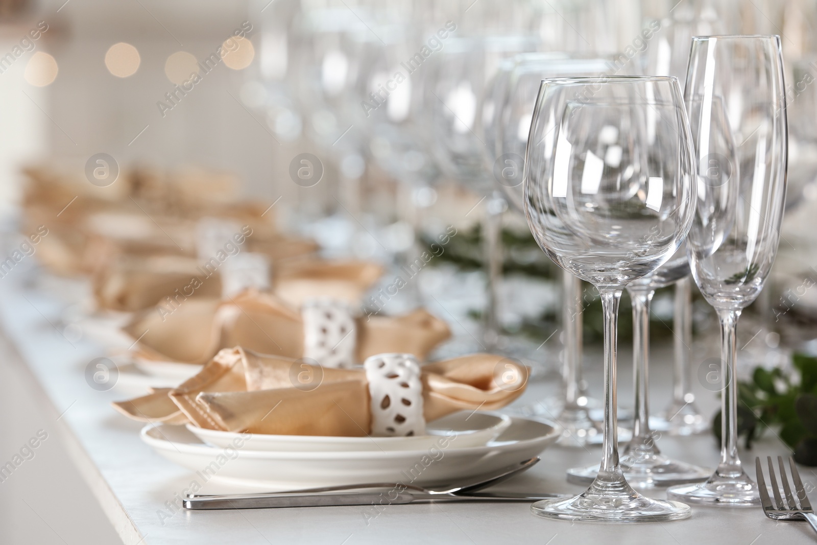 Photo of Table setting with empty glasses, plates and cutlery indoors