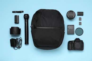 Professional photography equipment and backpack on turquoise background, flat lay