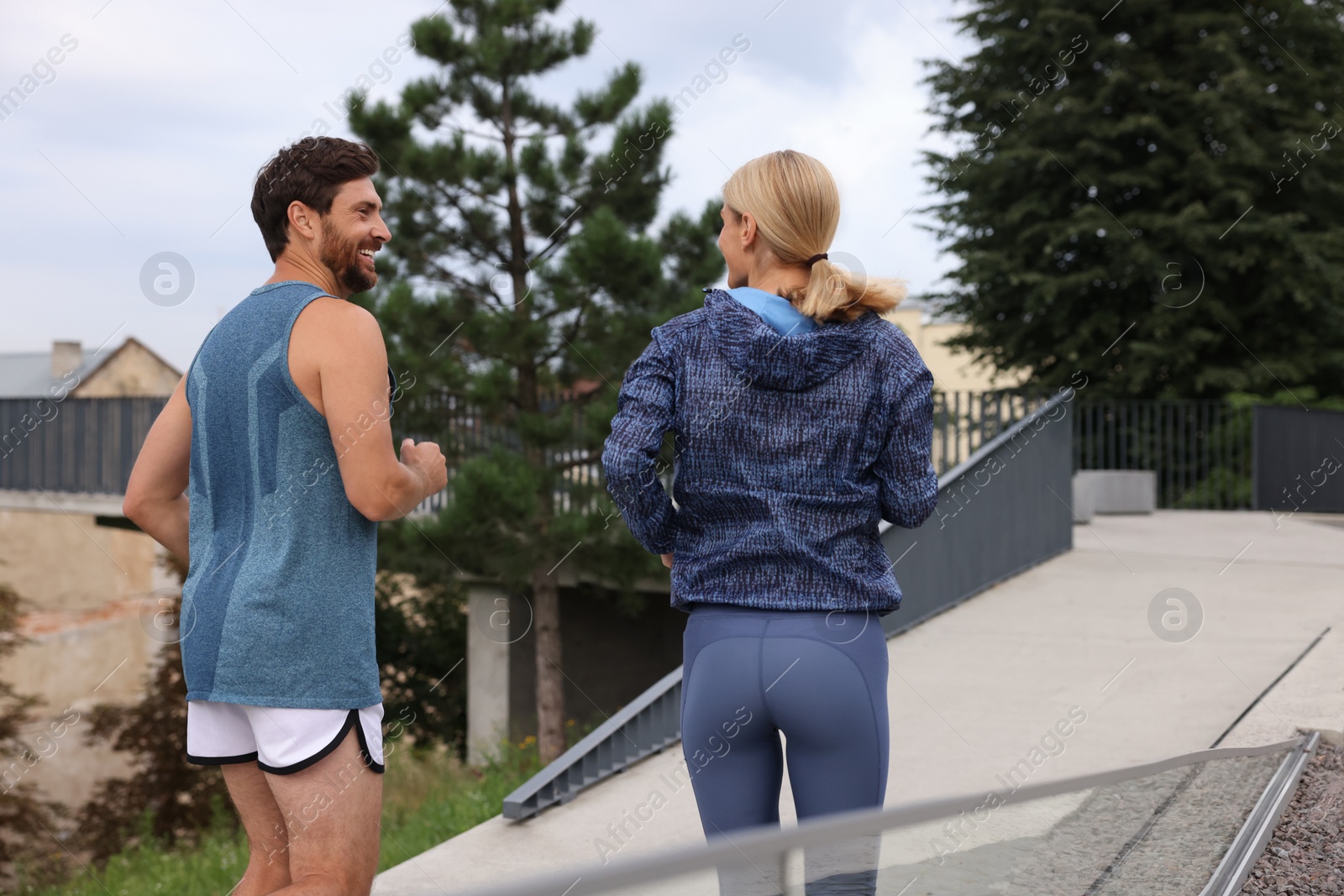 Photo of Healthy lifestyle. Happy sporty couple running outdoors