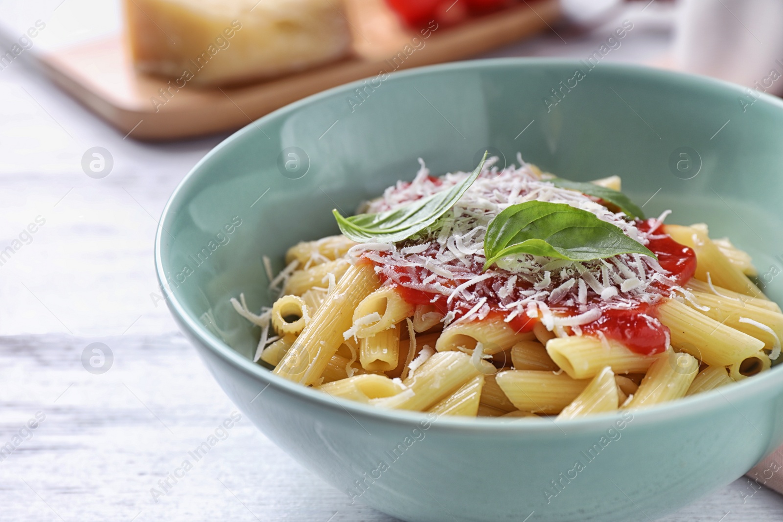 Photo of Delicious pasta with tomato sauce served on white wooden table, closeup