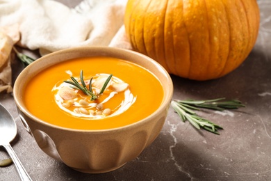 Delicious pumpkin soup in bowl on marble table