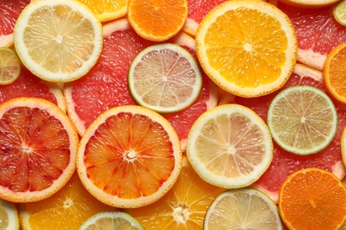 Slices of fresh citrus fruits as background, top view