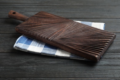 Kitchen towel and cutting board on black wooden table