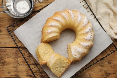 Photo of Delicious sponge cake served on wooden table, flat lay