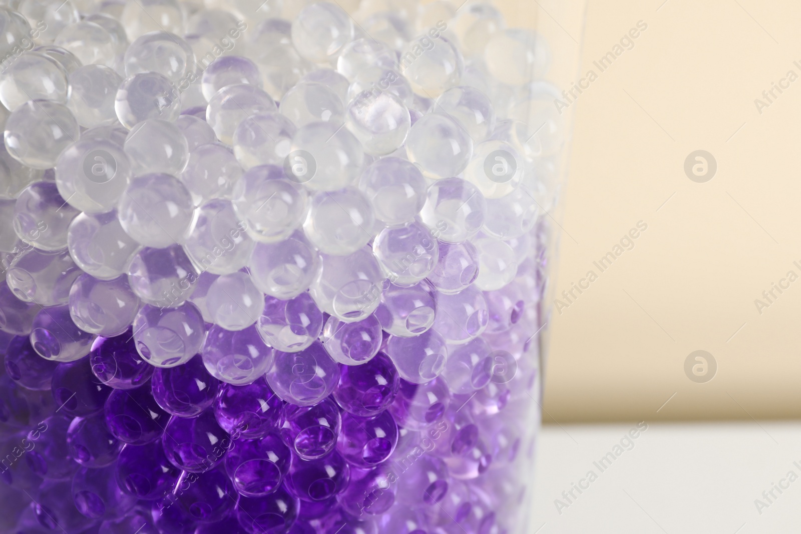 Photo of Different color fillers in glass vase, closeup. Water beads