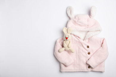 Photo of Child's clothes and toy bunny on white background, top view