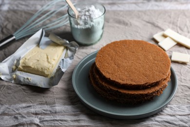 Delicious homemade sponge cakes and ingredients on grey tablecloth