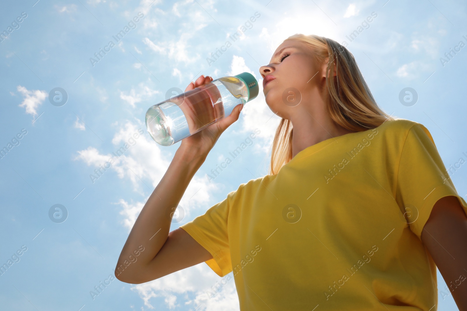 Photo of Woman drinking water to prevent heat stroke outdoors