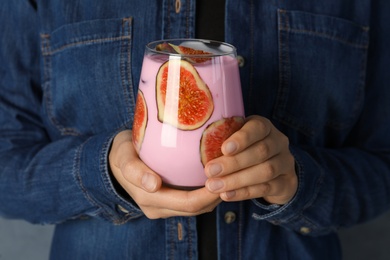 Photo of Woman holding fresh fig smoothie, closeup view