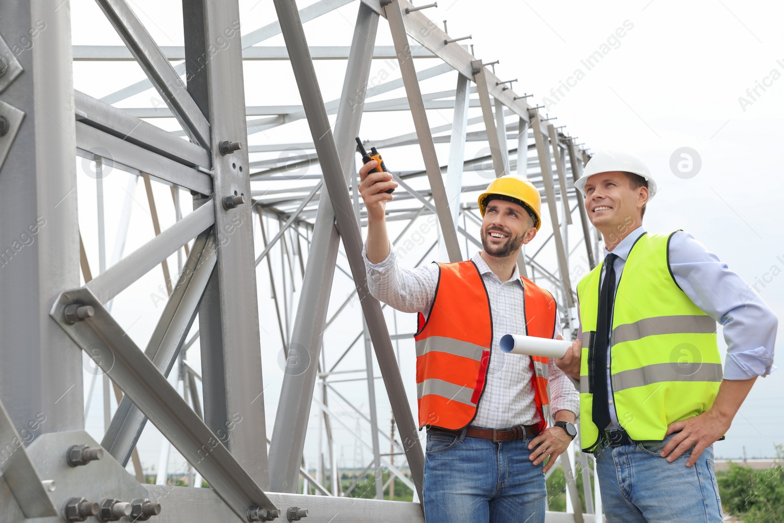 Photo of Professional engineers working on installation of electrical substation outdoors