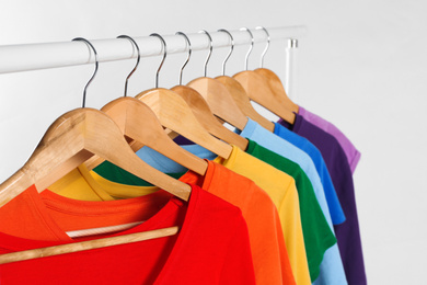 Colorful clothes on hangers against white background