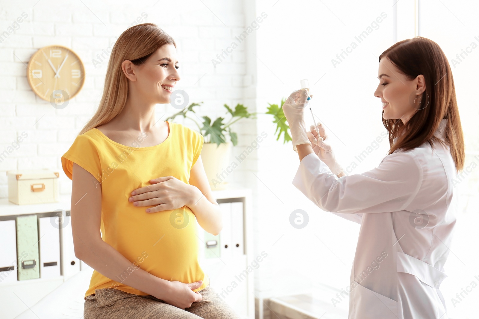 Photo of Doctor vaccinating pregnant woman in clinic