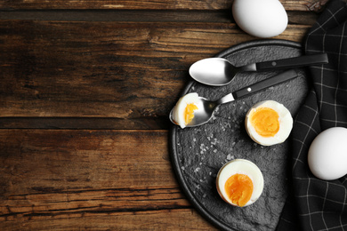 Photo of Tasty boiled chicken eggs on wooden table, flat lay. Space for text