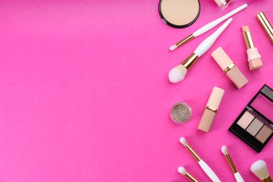 Flat lay composition with makeup brushes on bright pink background, space for text