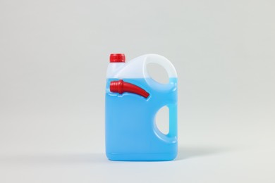 Photo of Plastic canister with nozzle and blue liquid on light grey background