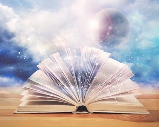 Image of Open book with glitter overlay and beautiful sky on background