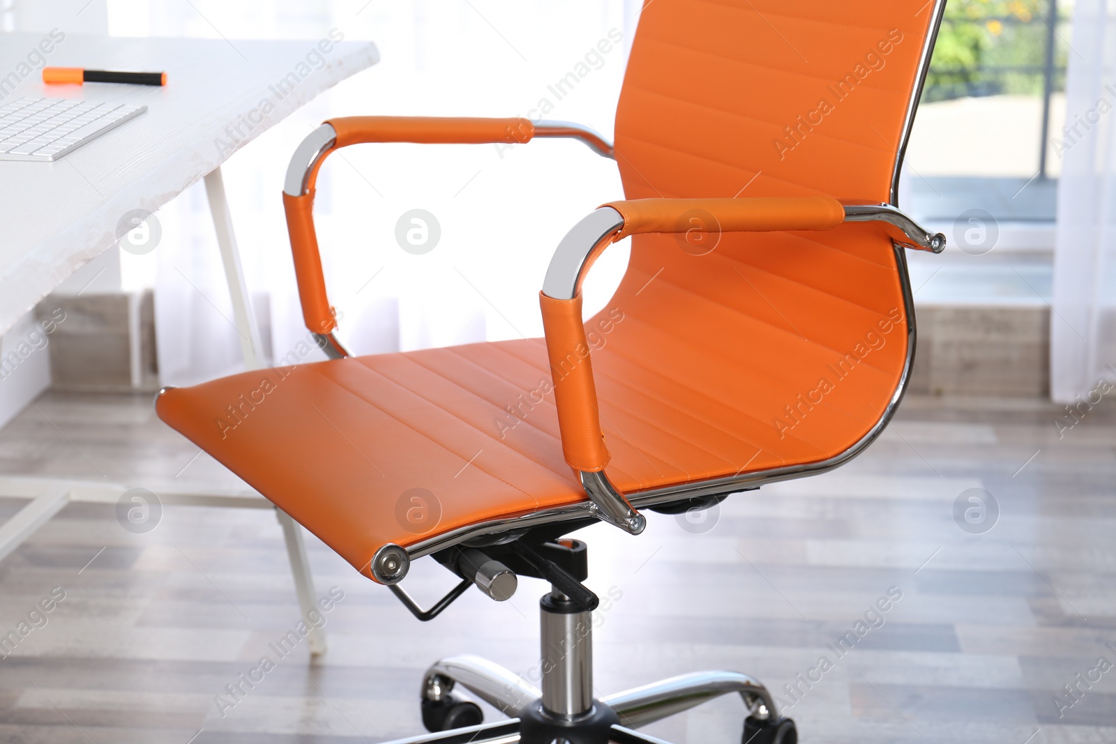 Photo of Comfortable workplace with office chair and wooden table, closeup