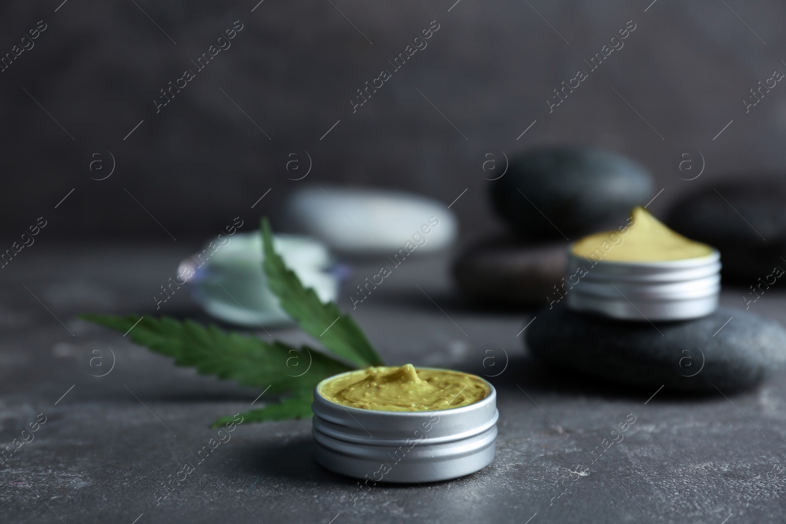 Photo of Jar with hemp lotion on grey table