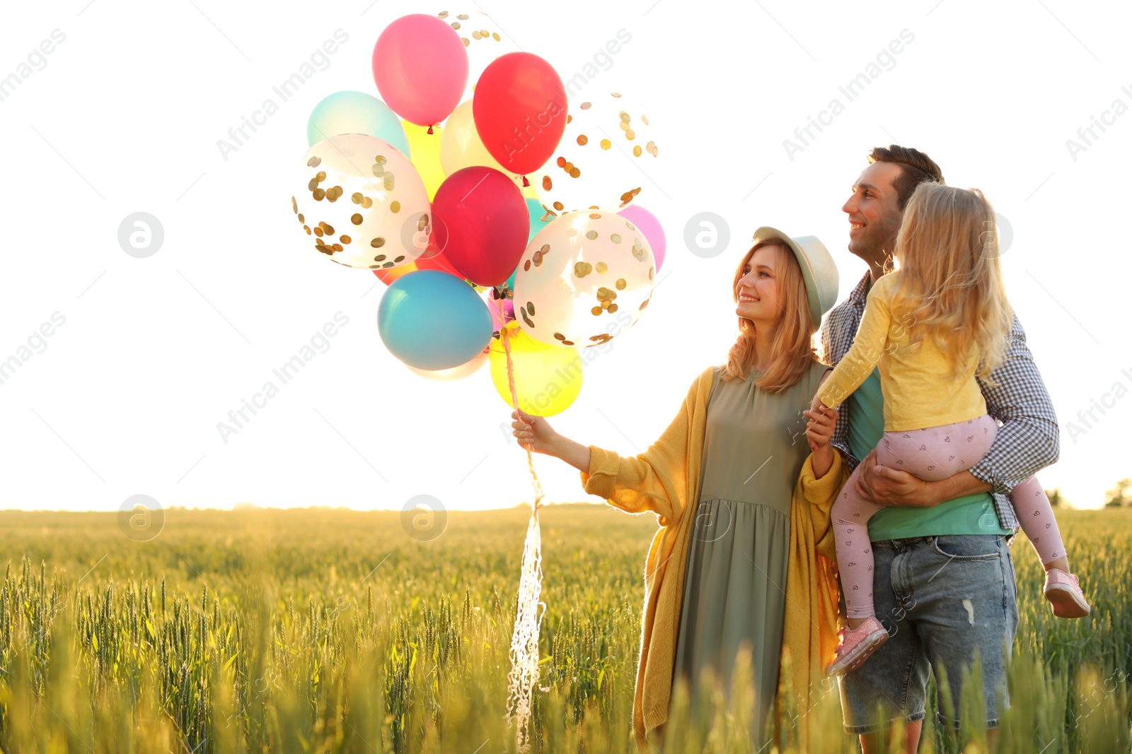 Photo of Happy family with colorful balloons outdoors on sunny day