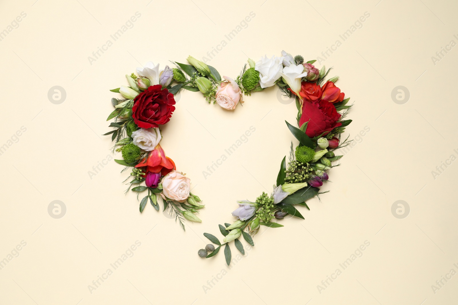 Photo of Beautiful heart made of different flowers on beige background, flat lay. Space for text