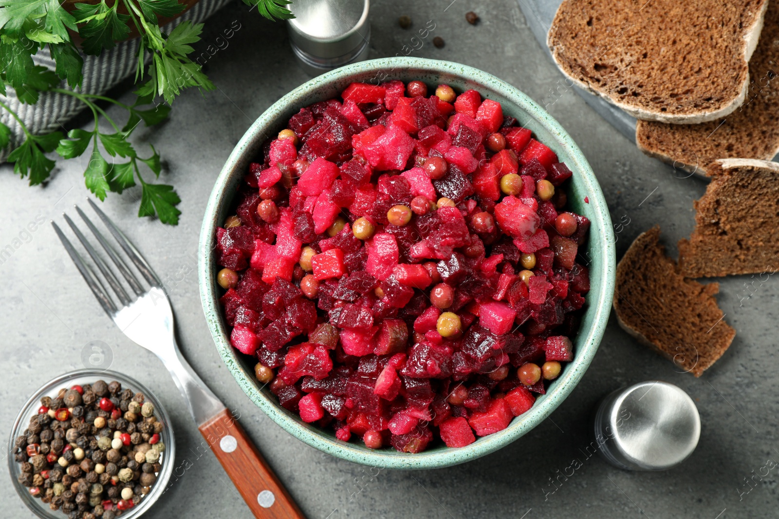 Photo of Traditional Russian salad vinaigrette served on grey table, flat lay