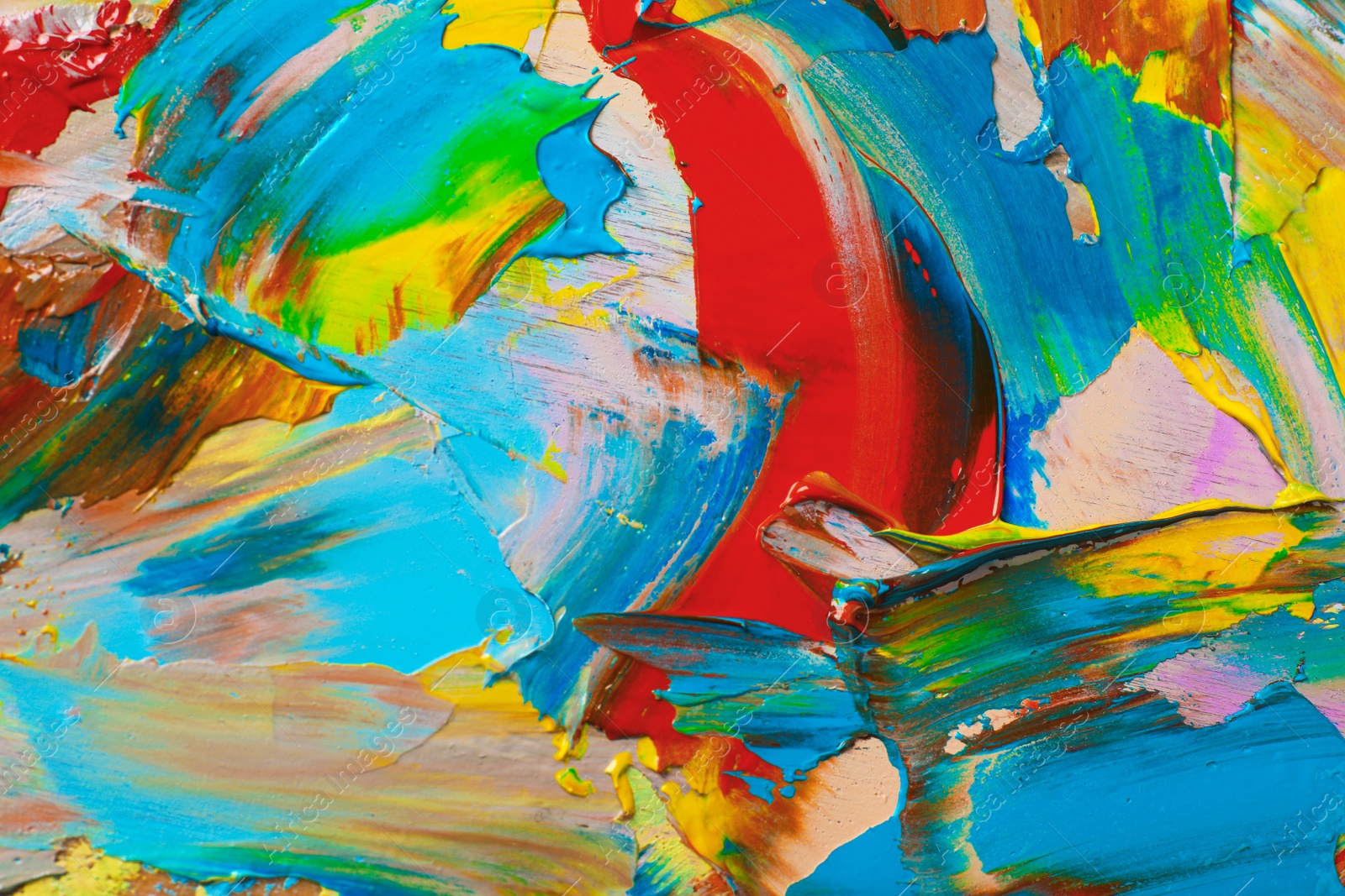 Photo of Closeup view of artist's palette with mixed bright paints as background