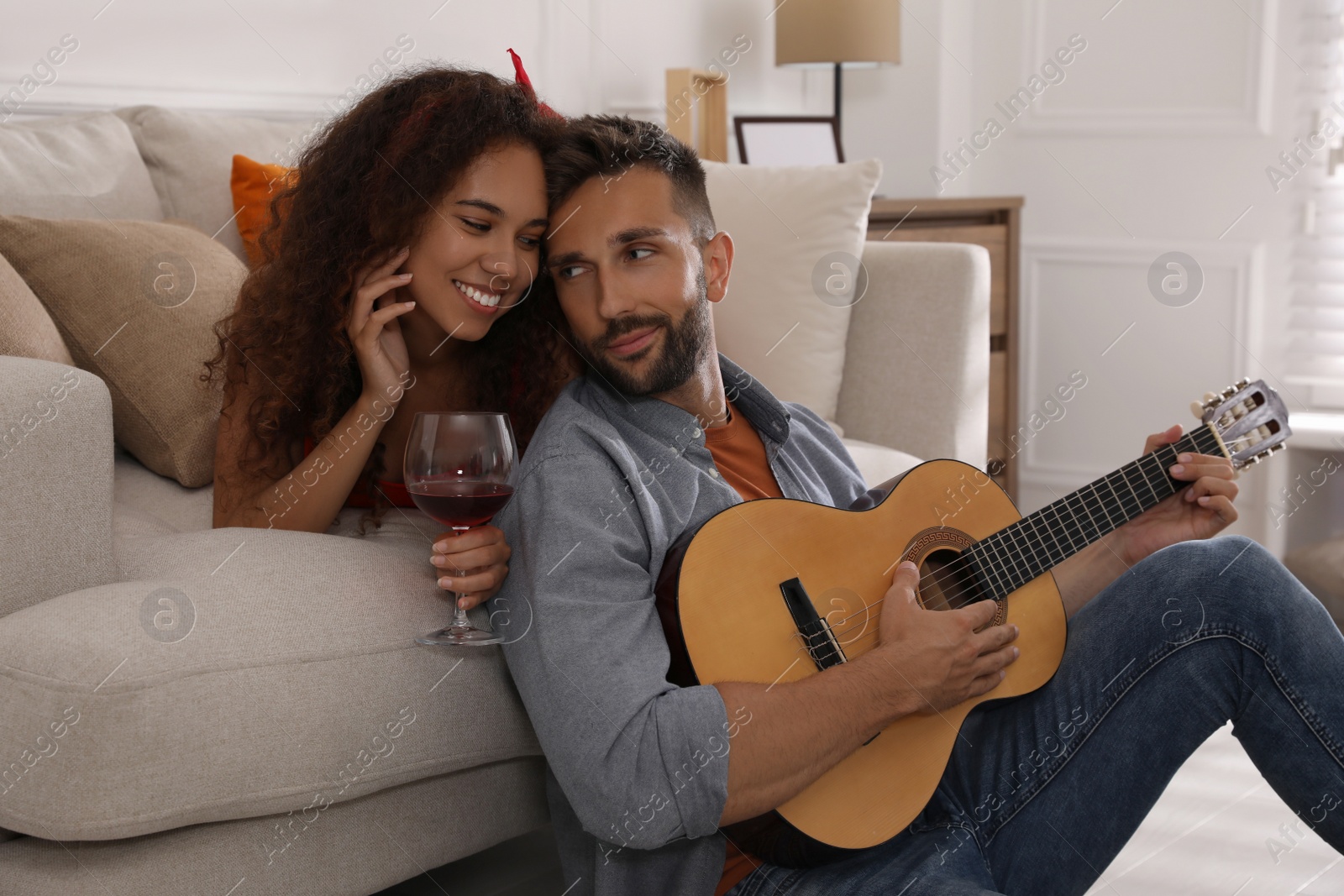 Photo of Lovely couple with guitar spending time together at home