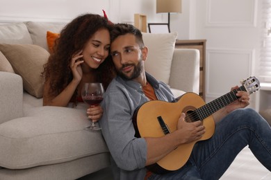 Photo of Lovely couple with guitar spending time together at home