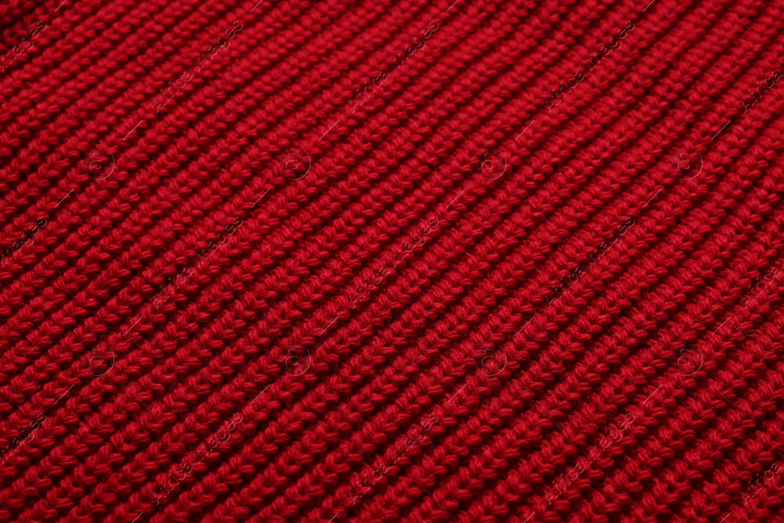 Photo of Texture of soft red knitted fabric as background, top view