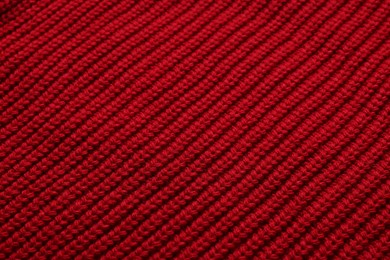 Texture of soft red knitted fabric as background, top view