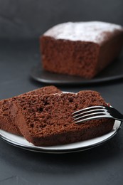 Pieces of tasty chocolate sponge cake on black table