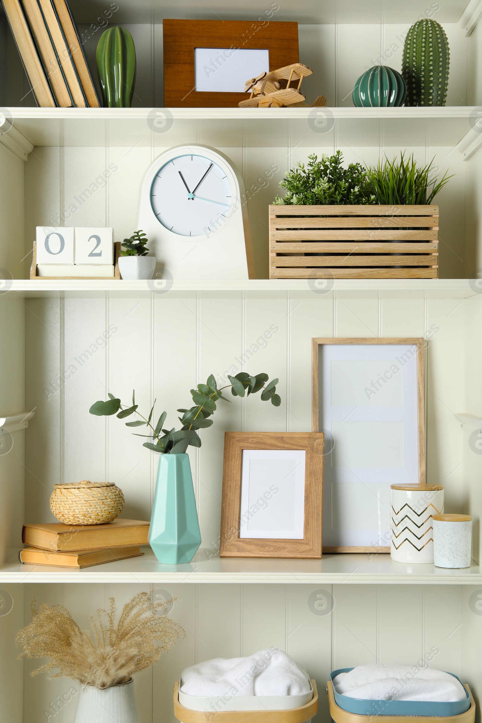 Photo of White shelving unit with photo frames and different decorative elements