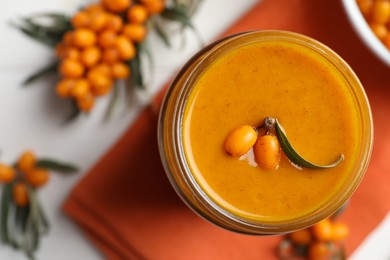 Delicious sea buckthorn jam on table, flat lay