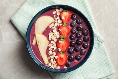 Flat lay composition with bowl of tasty acai smoothie on gray table