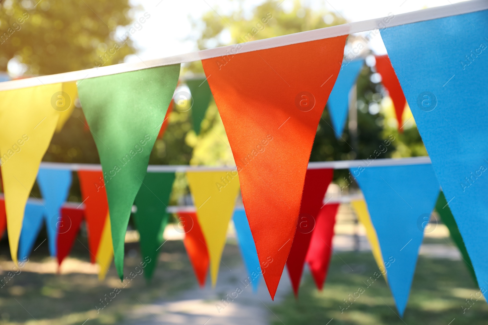 Photo of Colorful bunting flags in park. Party decor