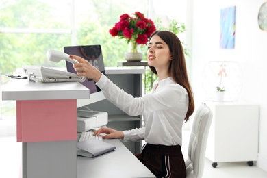 Photo of Beauty salon receptionist using computer at desk