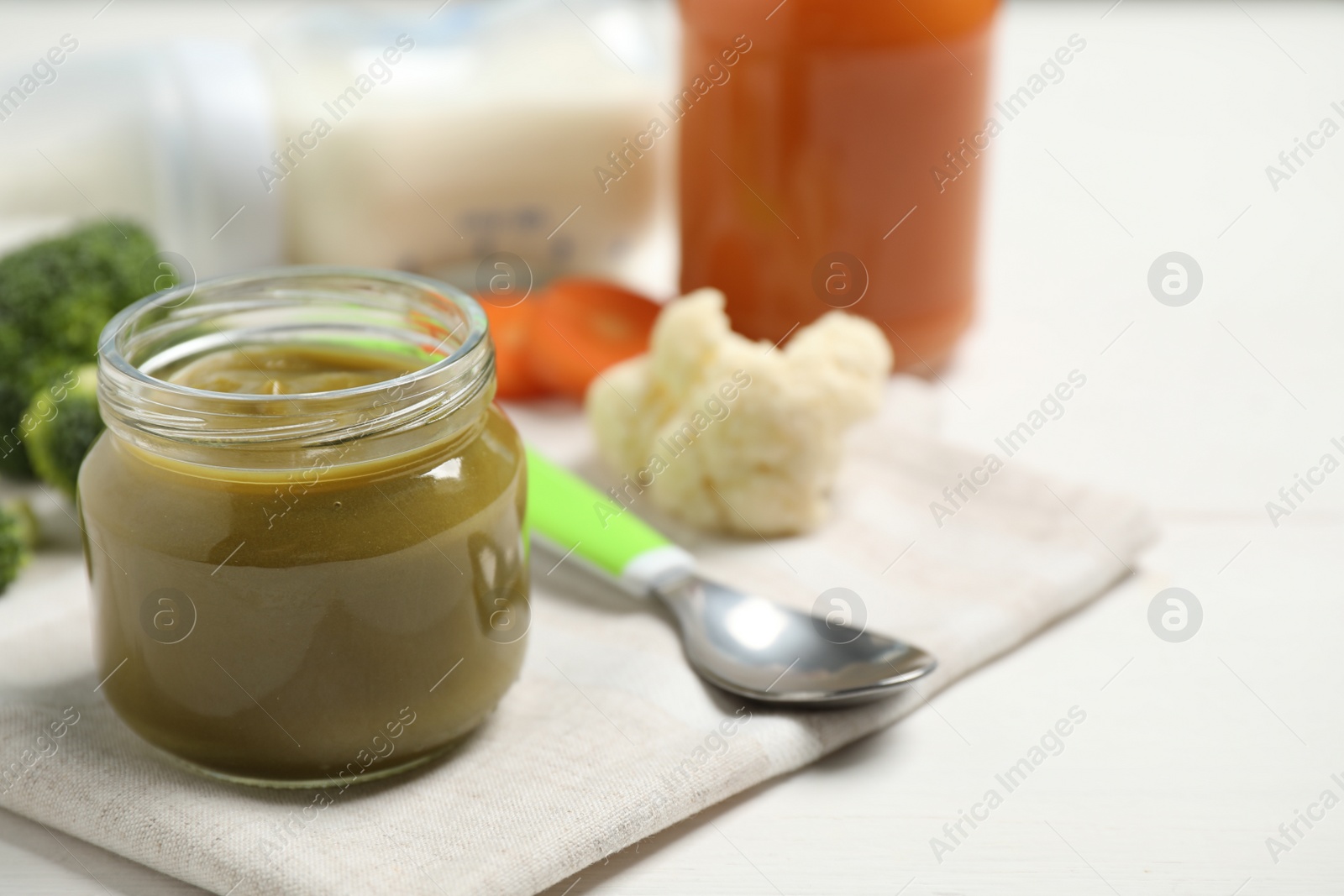 Photo of Healthy baby food and fresh ingredients on white table. Space for text