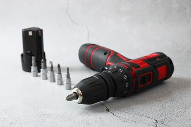 Photo of Electric screwdriver, drill bits and battery on light table