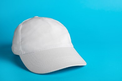 Photo of Baseball cap on light blue background, space for text
