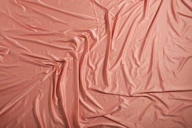 Crumpled coral fabric as background, closeup view