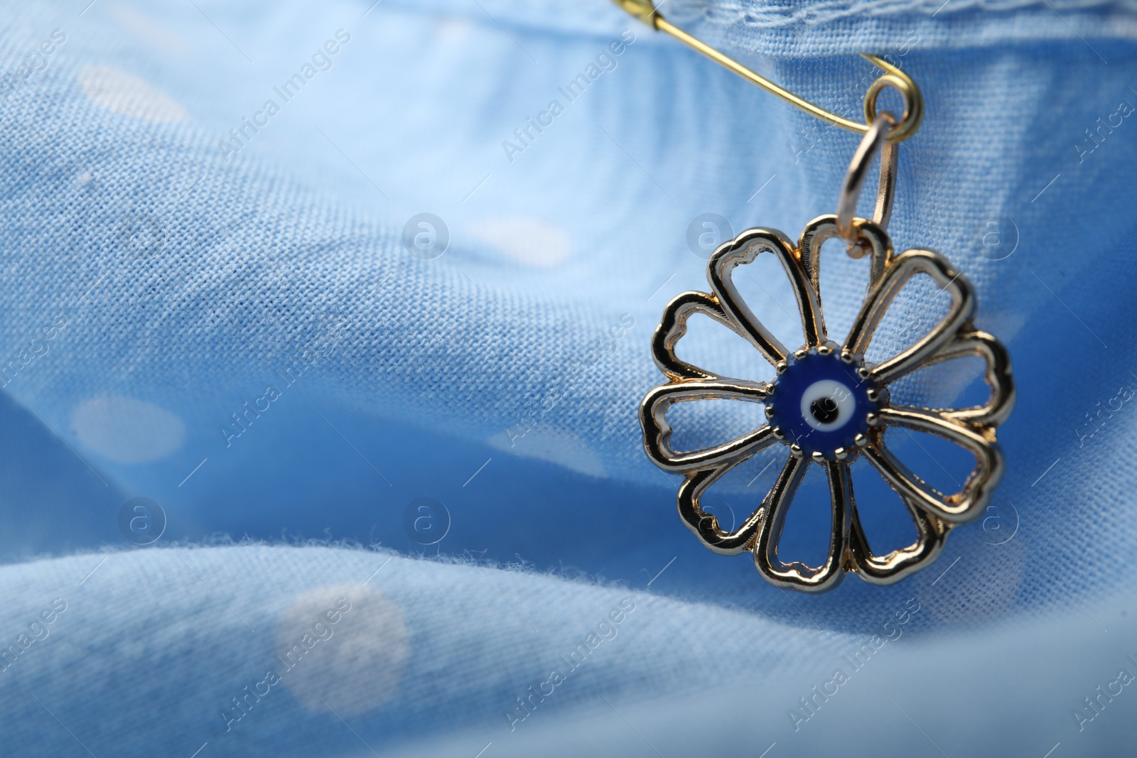 Photo of Evil eye safety pin on clothing, closeup