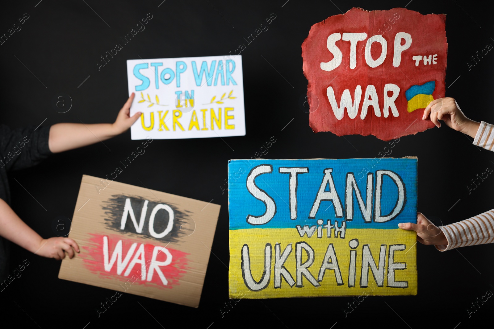 Photo of Stop war in Ukraine. People holding posters on black background