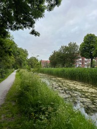 Photo of Picturesque view of water canal between trees and grass