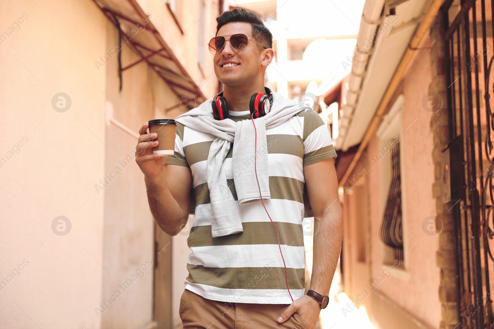 Photo of Happy man with coffee on city street in morning