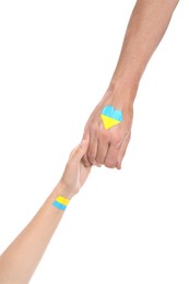 Man and woman with painted Ukrainian flags on their hands against white background, closeup