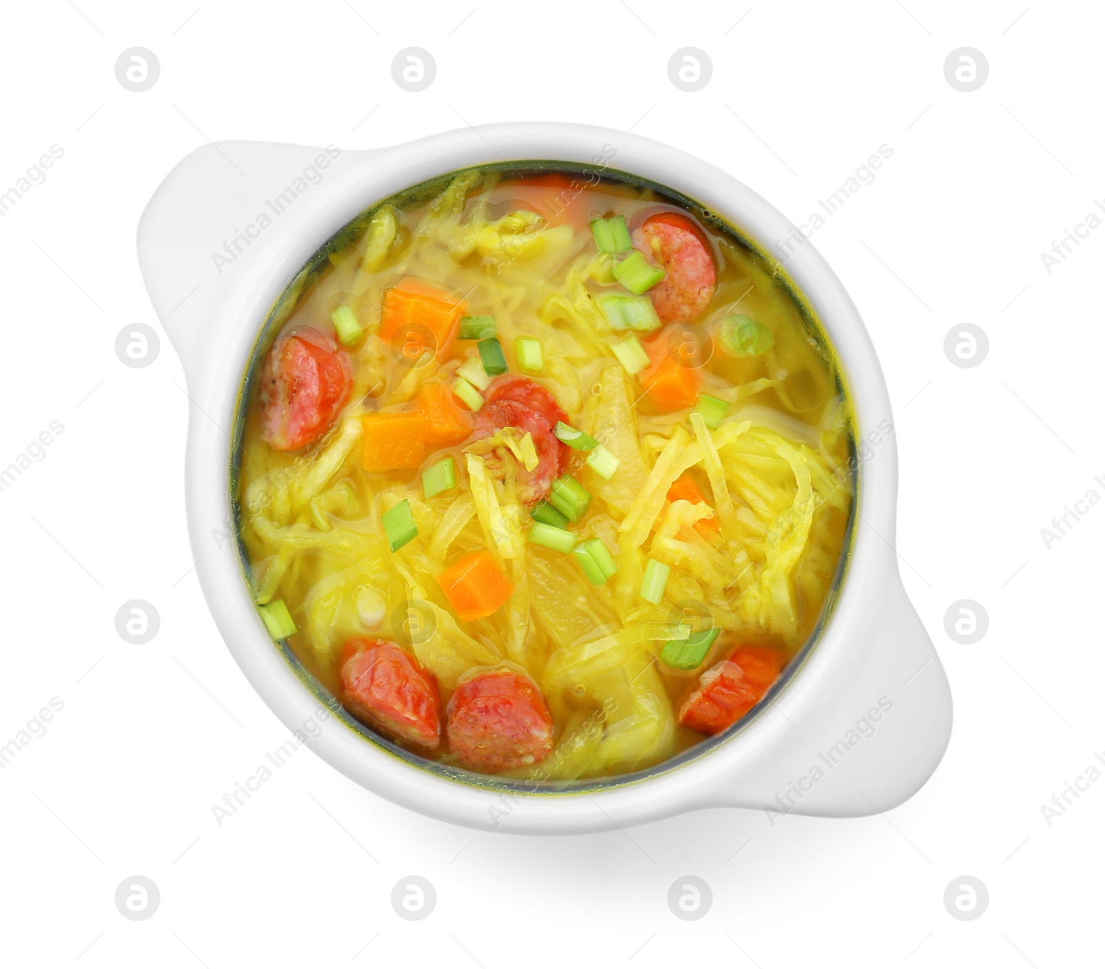 Photo of Bowl of delicious sauerkraut soup with smoked sausages and green onion isolated on white, top view