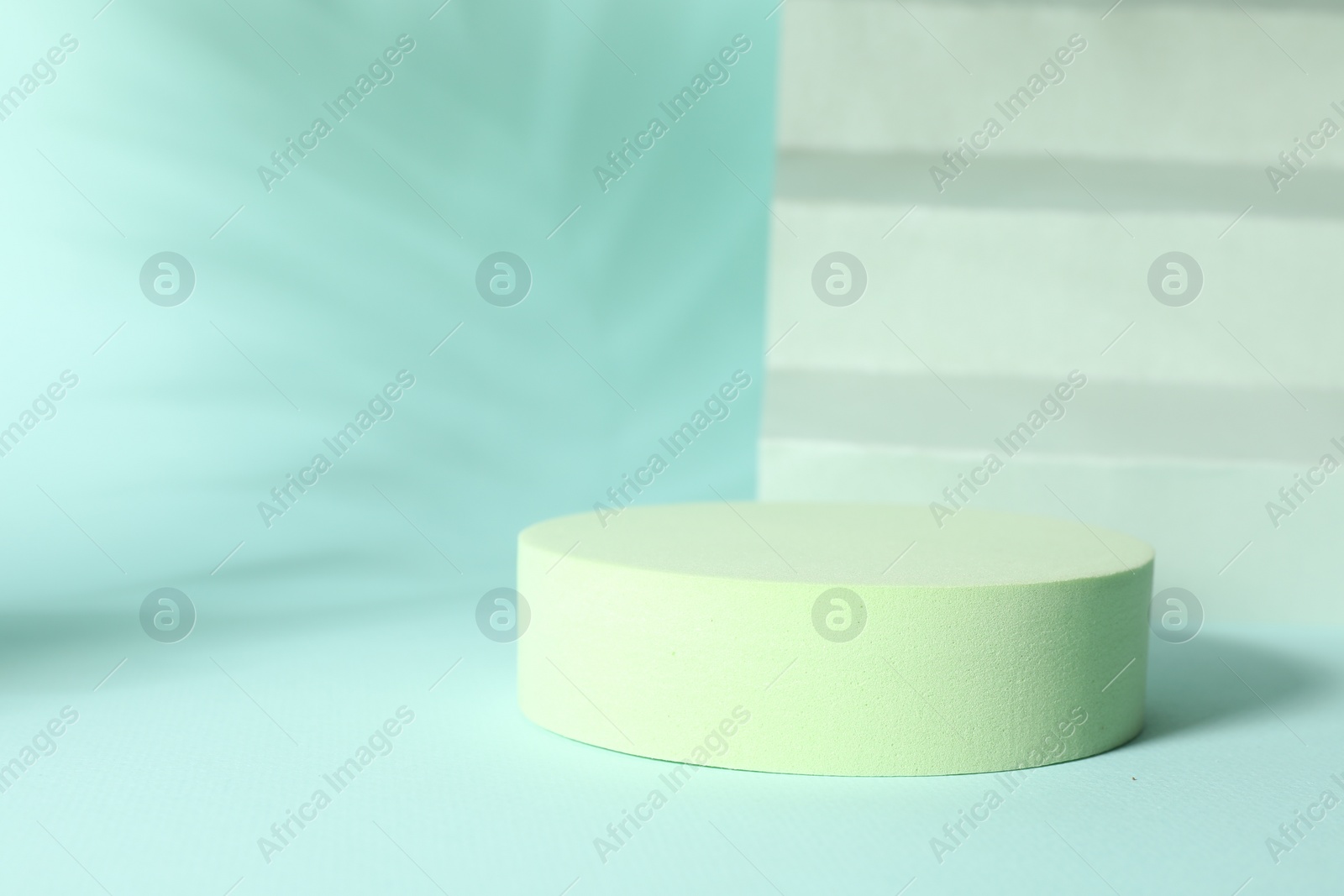 Photo of Presentation of product. Podium, paper and shadows on turquoise background. Space for text