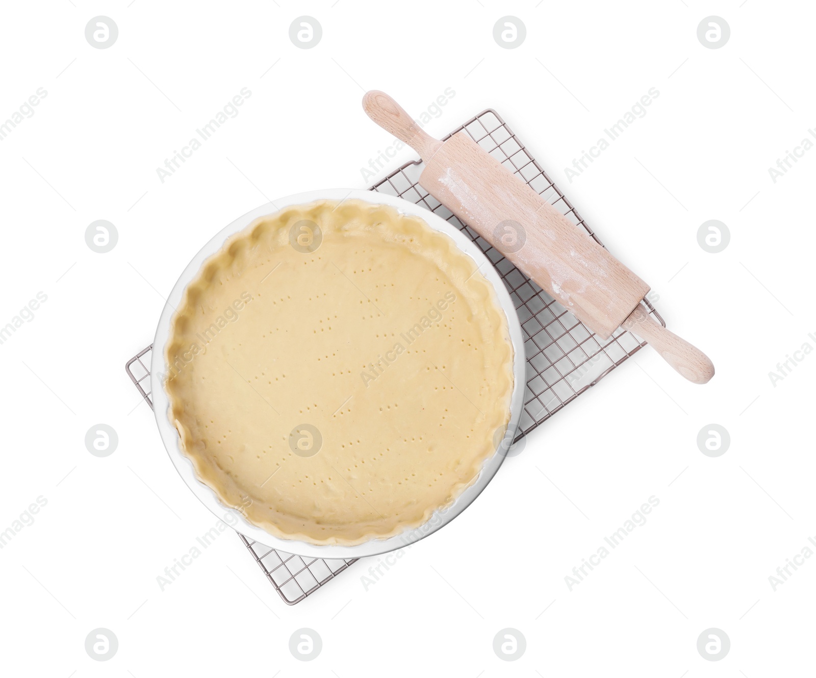 Photo of Quiche pan with fresh dough and rolling pin isolated on white, top view